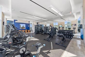A gym with treadmills, stationary bikes, and other exercise equipment.